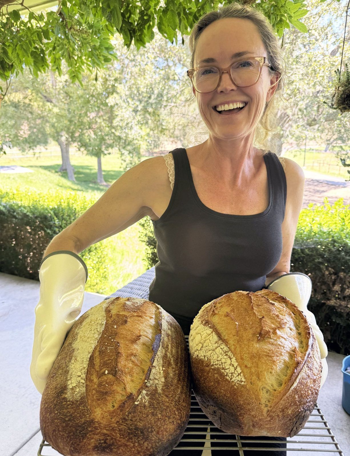 Codi holding two fresh-baked sourdough loaves